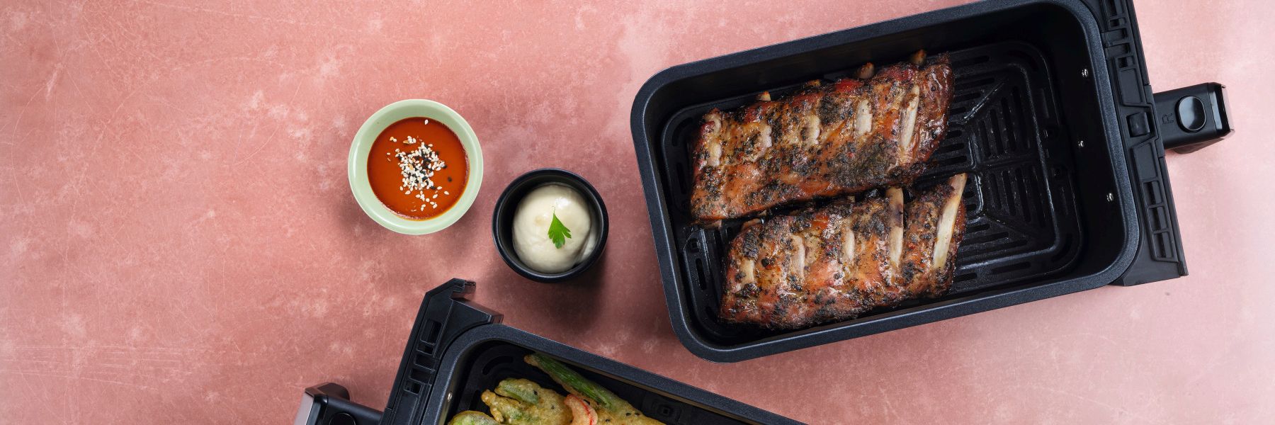 Spareribs im Airfryer neben knusprigem Gemüse im Tempurateig im Airfryer und zwei Dips