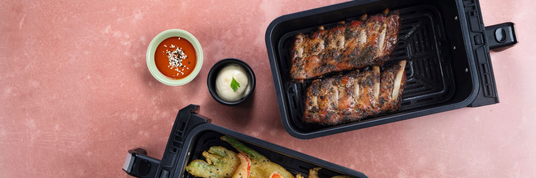 Spareribs im Airfryer neben knusprigem Gemüse im Tempurateig im Airfryer und zwei Dips